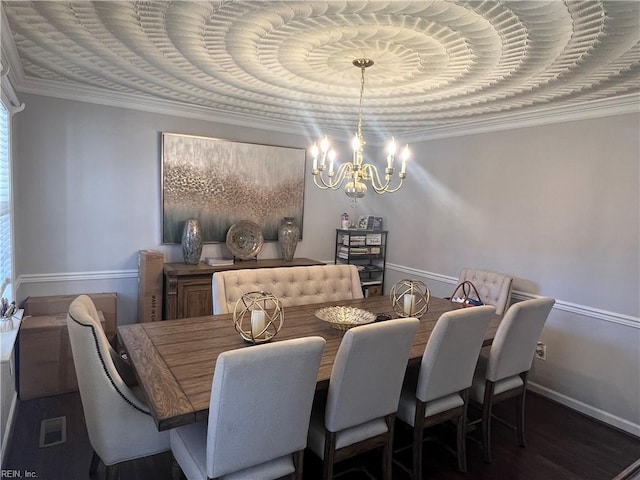 dining space featuring dark hardwood / wood-style flooring, a tray ceiling, crown molding, and a notable chandelier