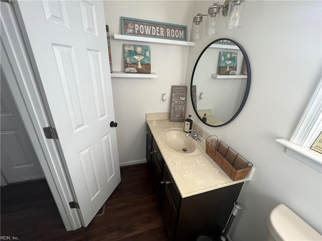 bathroom with hardwood / wood-style flooring, vanity, and toilet