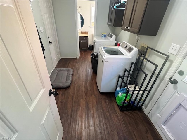 laundry area featuring cabinets, dark hardwood / wood-style flooring, and washing machine and clothes dryer