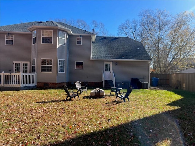 back of property featuring a fire pit and a lawn