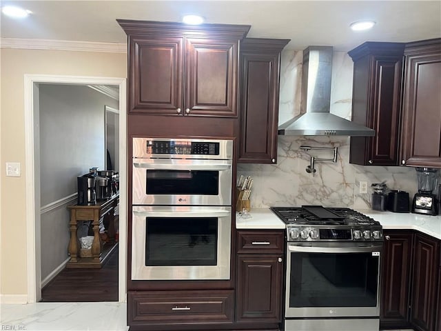 kitchen with wall chimney range hood, crown molding, appliances with stainless steel finishes, and tasteful backsplash