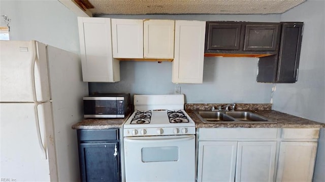 kitchen with a textured ceiling, white cabinetry, white appliances, and sink