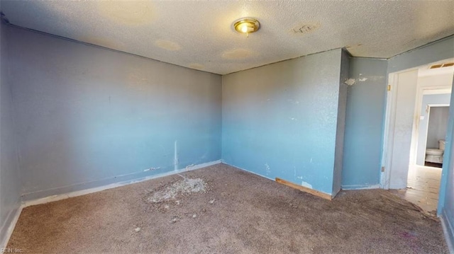 carpeted spare room with a textured ceiling