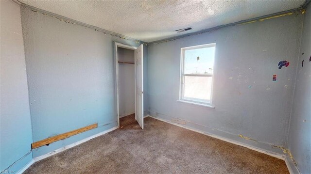 unfurnished bedroom featuring a textured ceiling and carpet floors