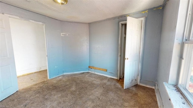 carpeted spare room with a textured ceiling