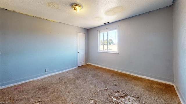 carpeted empty room with a textured ceiling