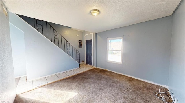 entryway with carpet floors and a textured ceiling