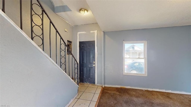 foyer entrance featuring light colored carpet