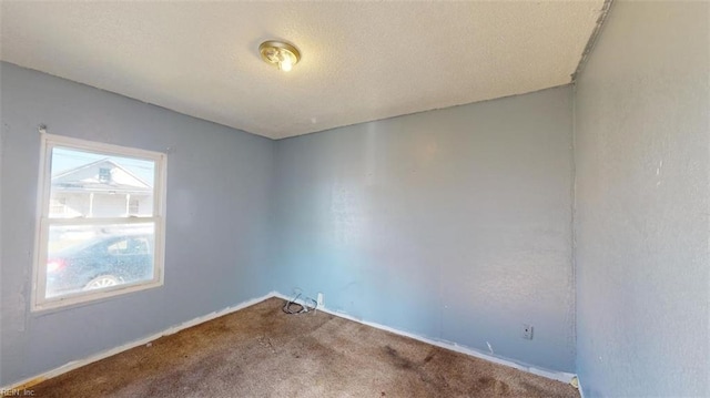 carpeted empty room featuring a textured ceiling