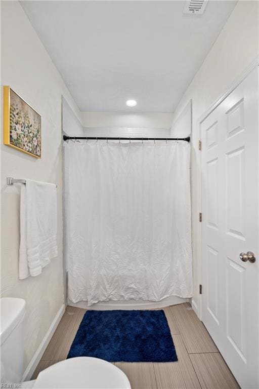 bathroom with hardwood / wood-style floors and toilet