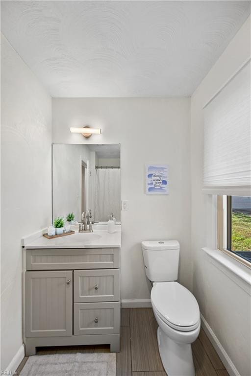 bathroom featuring vanity, hardwood / wood-style flooring, and toilet