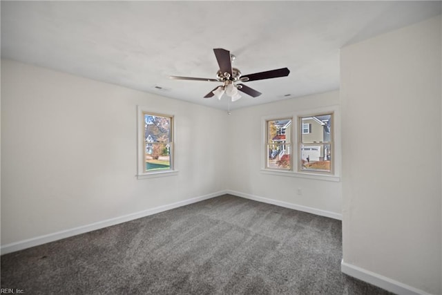 spare room with carpet flooring, ceiling fan, and a wealth of natural light