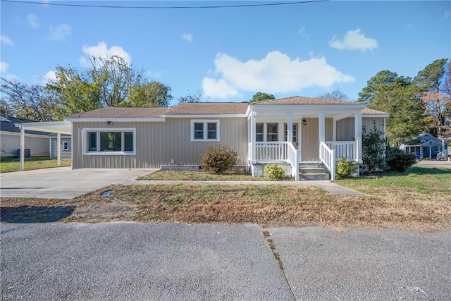 ranch-style home featuring a carport and covered porch