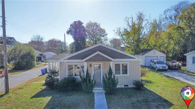 view of front of home with a garage, an outdoor structure, and a front yard