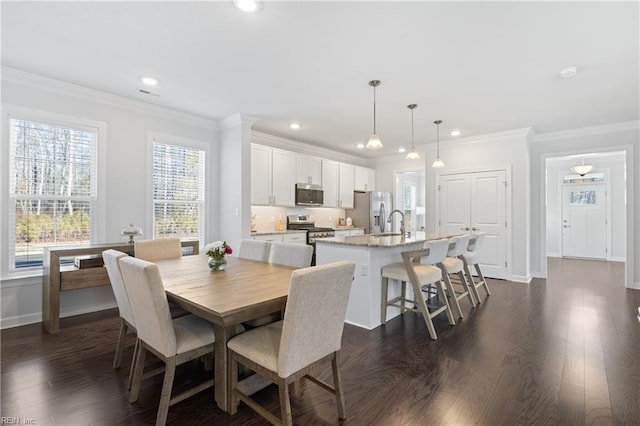 dining room with dark hardwood / wood-style floors, ornamental molding, and sink