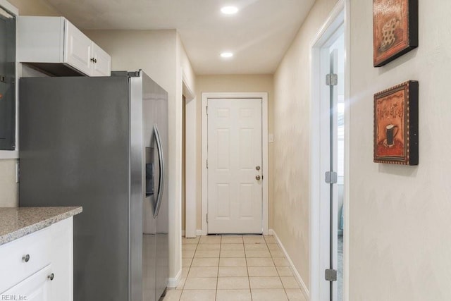 kitchen featuring light tile patterned flooring, white cabinetry, and stainless steel refrigerator with ice dispenser