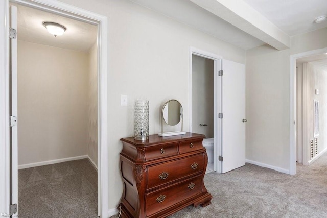 hall with light carpet and beamed ceiling