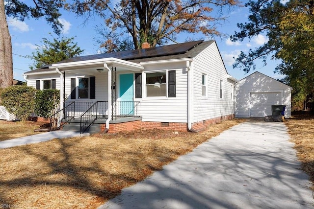 view of front of property featuring covered porch, solar panels, a garage, and an outdoor structure