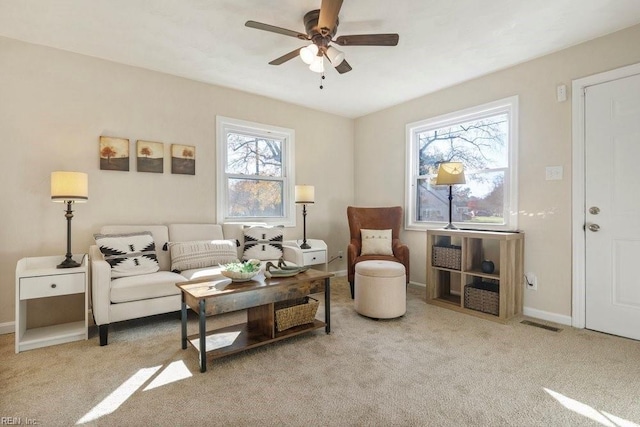 carpeted living room with ceiling fan