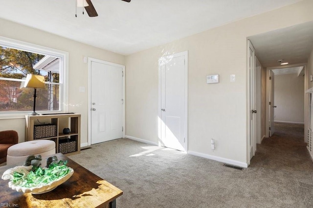 interior space featuring light carpet and ceiling fan