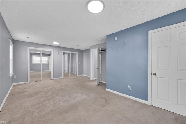 unfurnished bedroom with light carpet and a textured ceiling