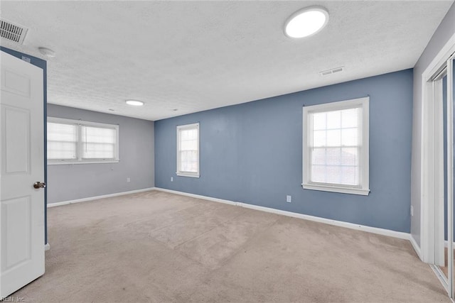 carpeted spare room featuring a textured ceiling