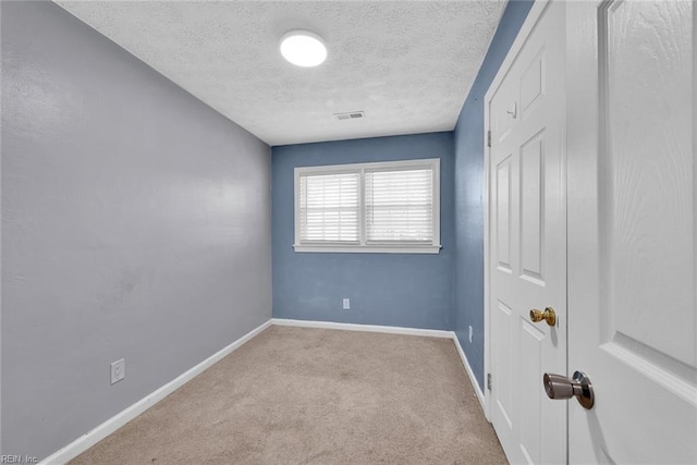 carpeted spare room featuring a textured ceiling