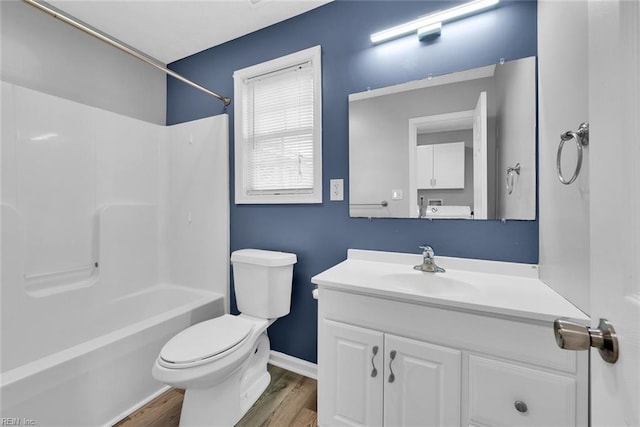 full bathroom with hardwood / wood-style floors, vanity, toilet, and shower / washtub combination