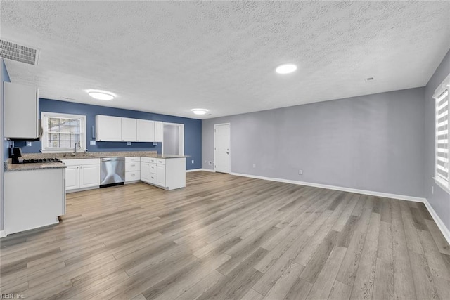 kitchen featuring dishwasher, white cabinetry, a textured ceiling, and light hardwood / wood-style flooring