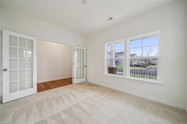 carpeted empty room featuring french doors