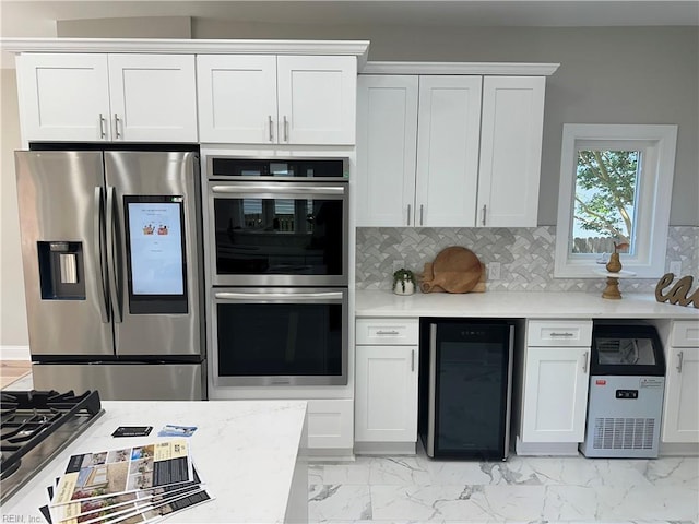 kitchen featuring appliances with stainless steel finishes, white cabinetry, and beverage cooler