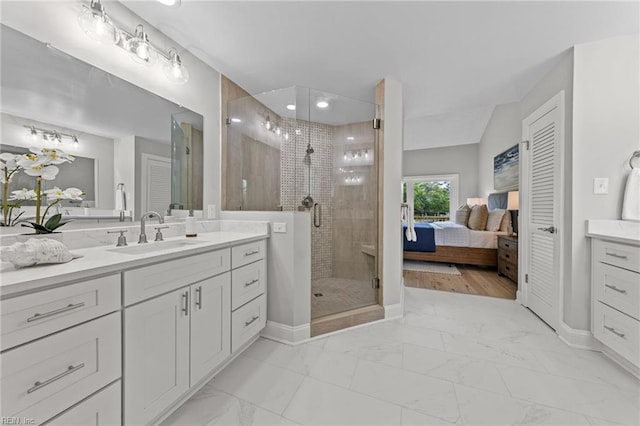 bathroom featuring a shower with door and vanity