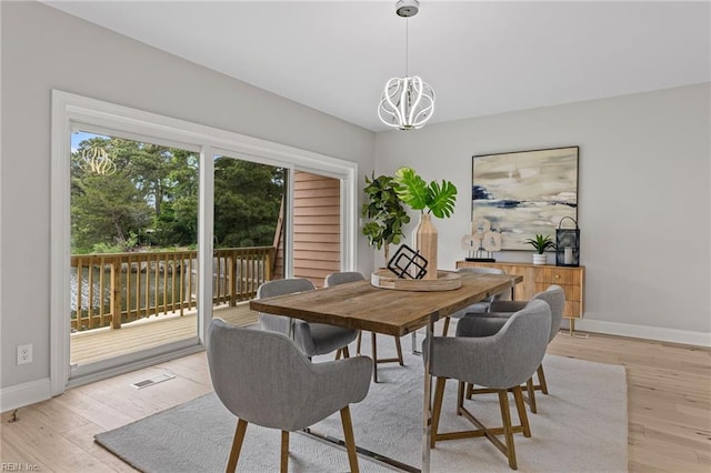 dining area with a chandelier and light hardwood / wood-style floors