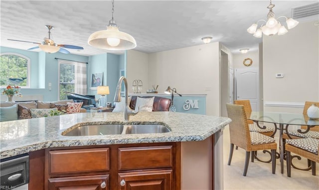 kitchen featuring decorative light fixtures, ceiling fan with notable chandelier, light colored carpet, and sink