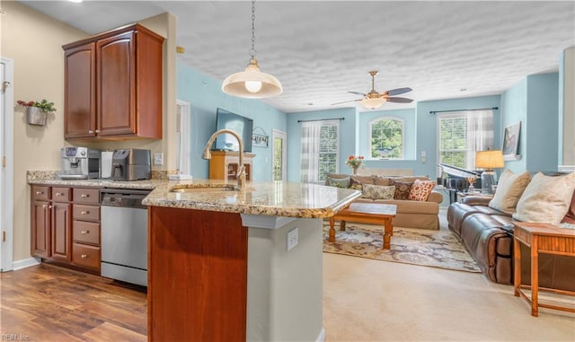 kitchen featuring light stone countertops, stainless steel dishwasher, ceiling fan, pendant lighting, and dark hardwood / wood-style floors