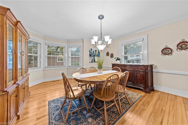 dining room with crown molding, light hardwood / wood-style floors, and a notable chandelier