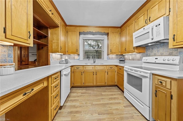 kitchen with white appliances, light hardwood / wood-style floors, tasteful backsplash, and sink