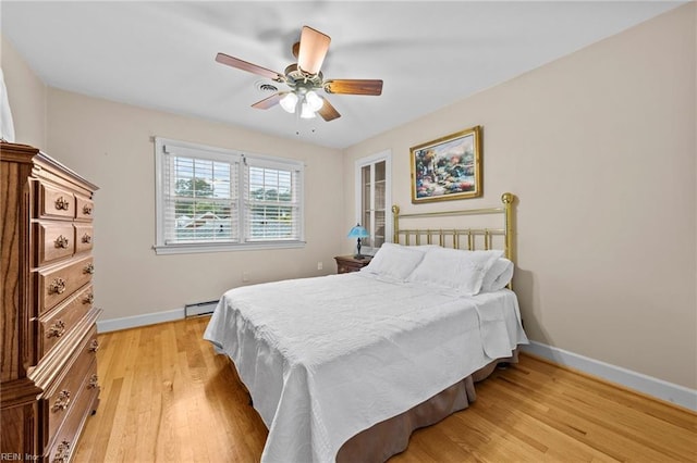 bedroom with baseboard heating, ceiling fan, and light hardwood / wood-style floors