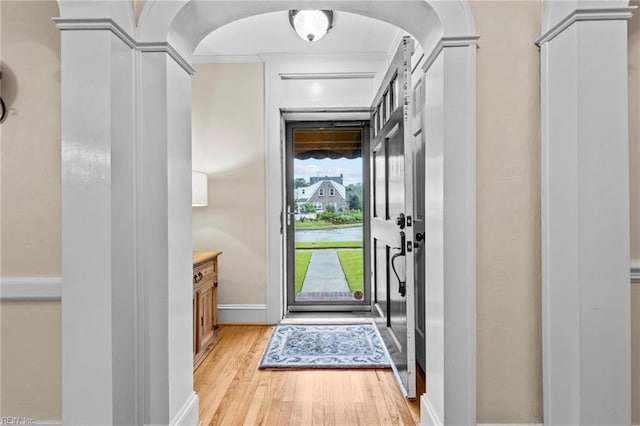 doorway to outside featuring light wood-type flooring and ornamental molding