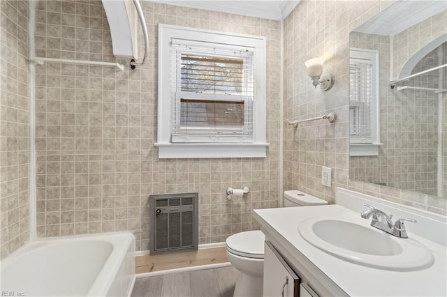 bathroom with hardwood / wood-style flooring, ornamental molding, tile walls, and heating unit