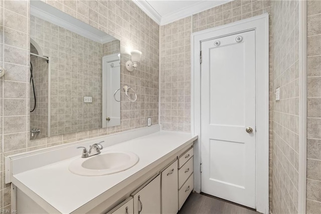 bathroom featuring vanity, wood-type flooring, tile walls, and ornamental molding