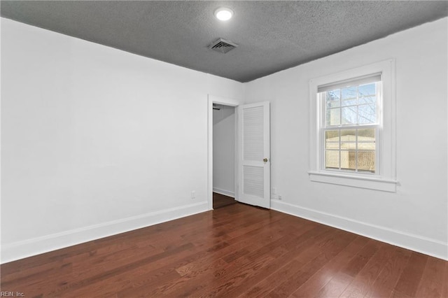 unfurnished bedroom featuring dark hardwood / wood-style flooring and a textured ceiling