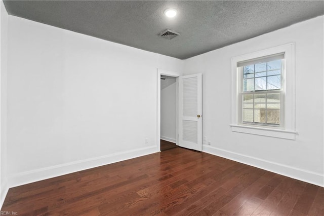 unfurnished bedroom featuring dark wood-type flooring and a textured ceiling