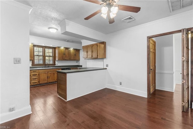 kitchen with kitchen peninsula, dark hardwood / wood-style flooring, ceiling fan, crown molding, and sink