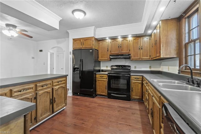 kitchen featuring dark wood-type flooring, black appliances, crown molding, sink, and a textured ceiling