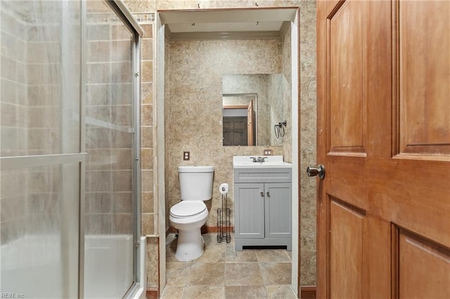 bathroom with toilet, vanity, a shower with shower door, and ornamental molding