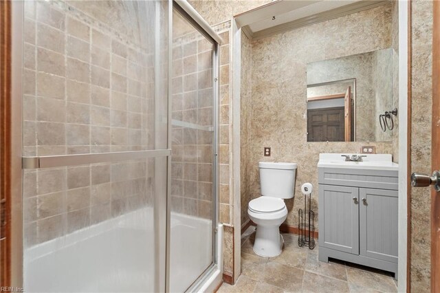 bathroom featuring crown molding, a shower with door, vanity, and toilet