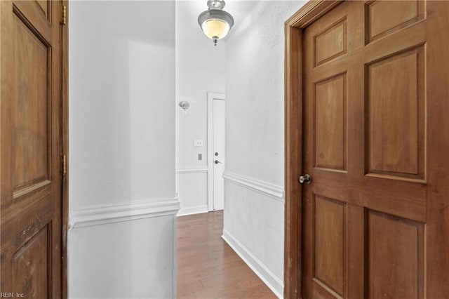 hallway with hardwood / wood-style flooring