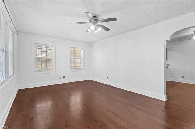 unfurnished room with a textured ceiling, dark hardwood / wood-style floors, and ceiling fan