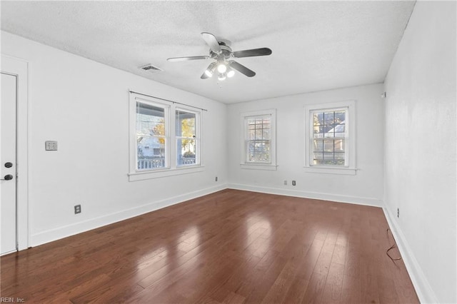 unfurnished room featuring dark hardwood / wood-style floors, ceiling fan, and a textured ceiling